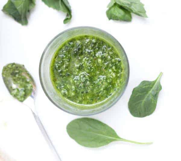 Glass container filled with spinach basil pesto