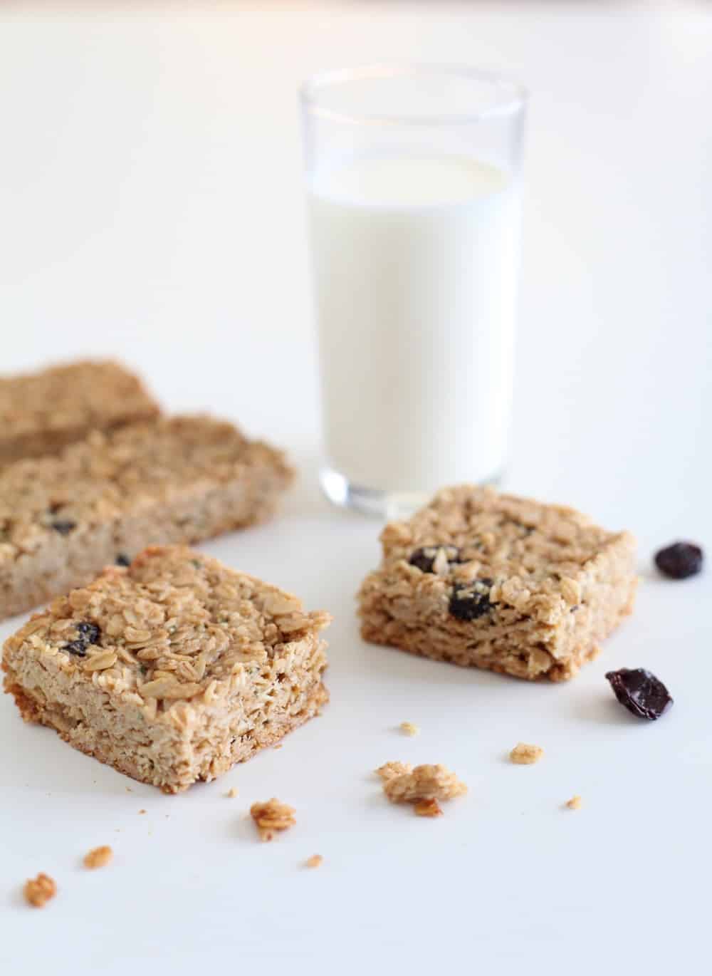 Tahini and dried cherry granola bars next to a glass of milk