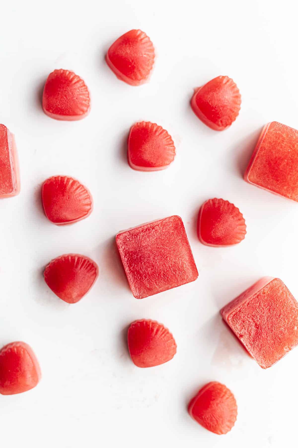 Bright red Frozen Watermelon and Coconut Water Ice Cubes in small square and sea shell shapes