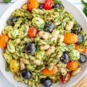 Spinach Pesto Pasta Salad with White Beans, Mozzarella and Tomatoes in a bowl