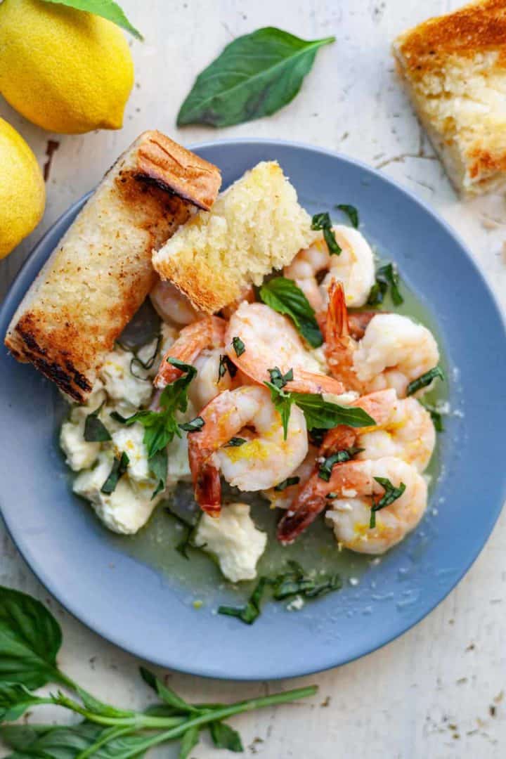 Cooked shrimp, feta and a slice of garlic bread with basil on top