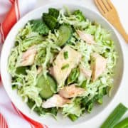 bowl of salmon and cucumber salad with shredded cabbage