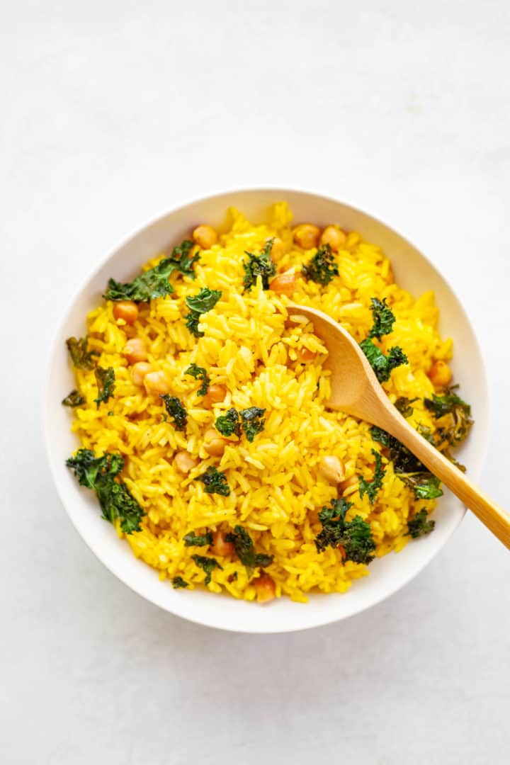 Bowl with yellow turmeric coconut rice, kale and chickpeas