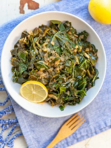 bowl of collard greens topped with chopped onion cooked in the instant pot