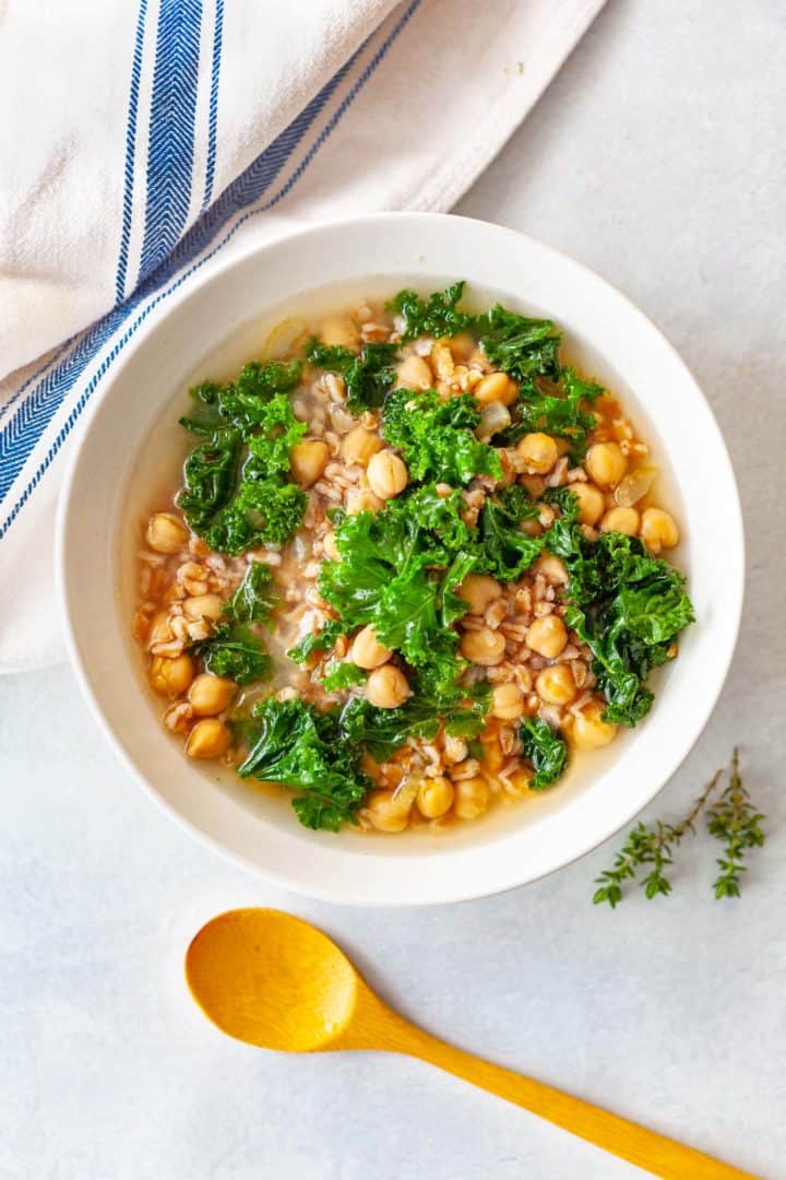 bowl of farro, chickpea and kale soup with lemon-ginger broth