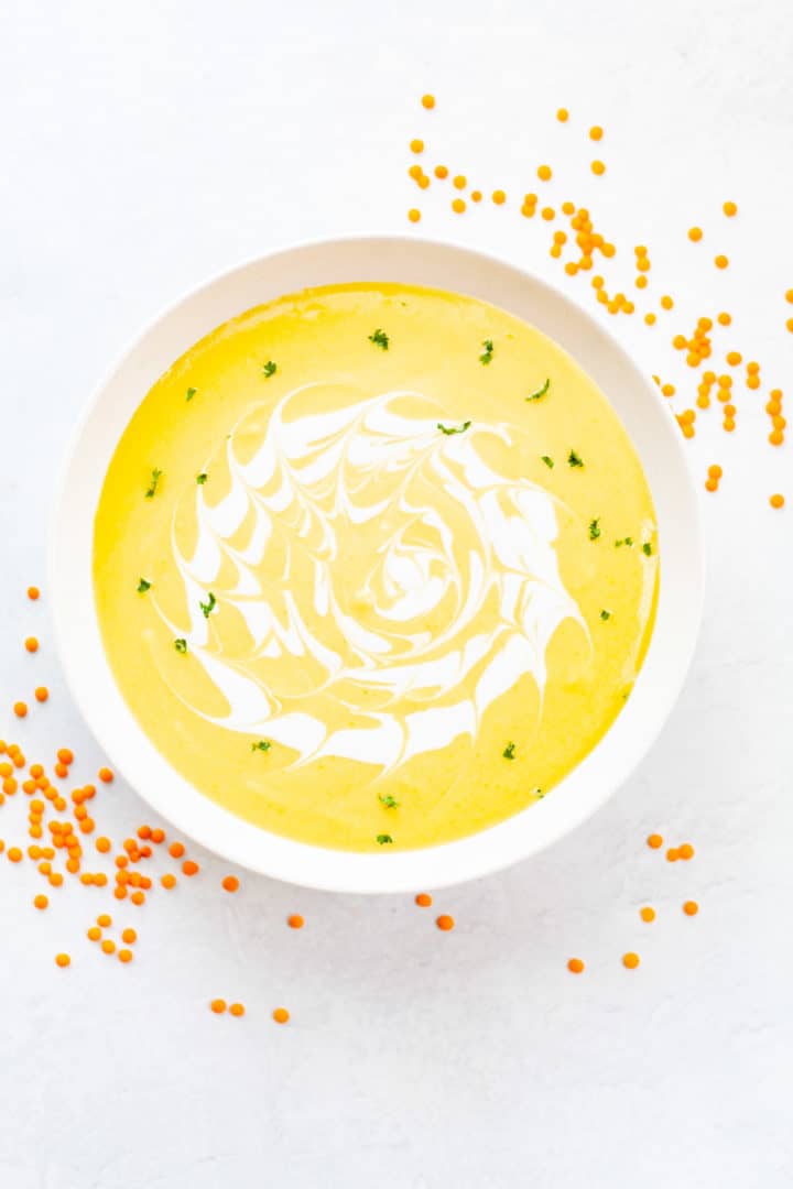 a bowl of creamy, pureed red lentil soup with coconut milk