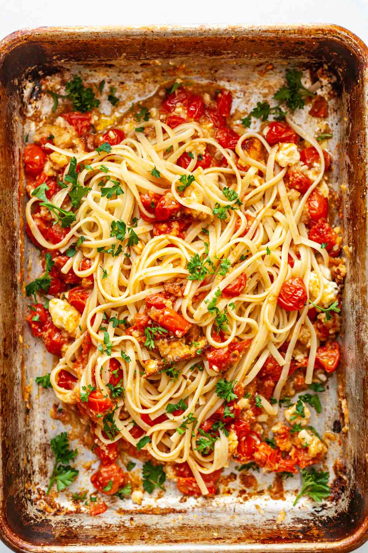 linguine in a pan with tomatoes and cheese