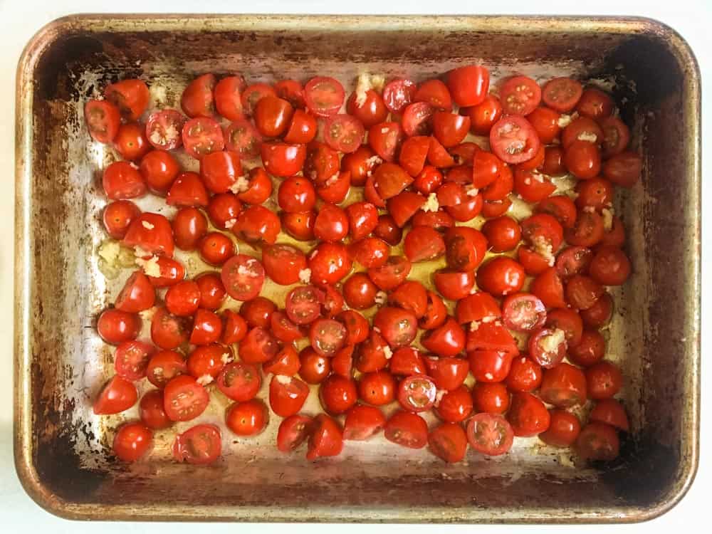 baking pan of halved cherry tomatoes, olive oil and garlic