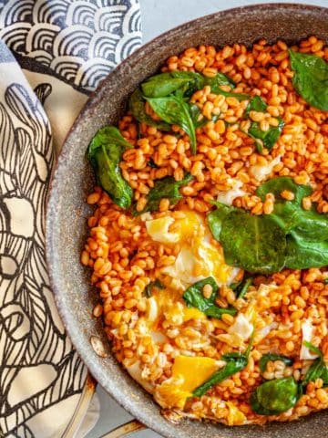 saute pan with barley, spinach and eggs