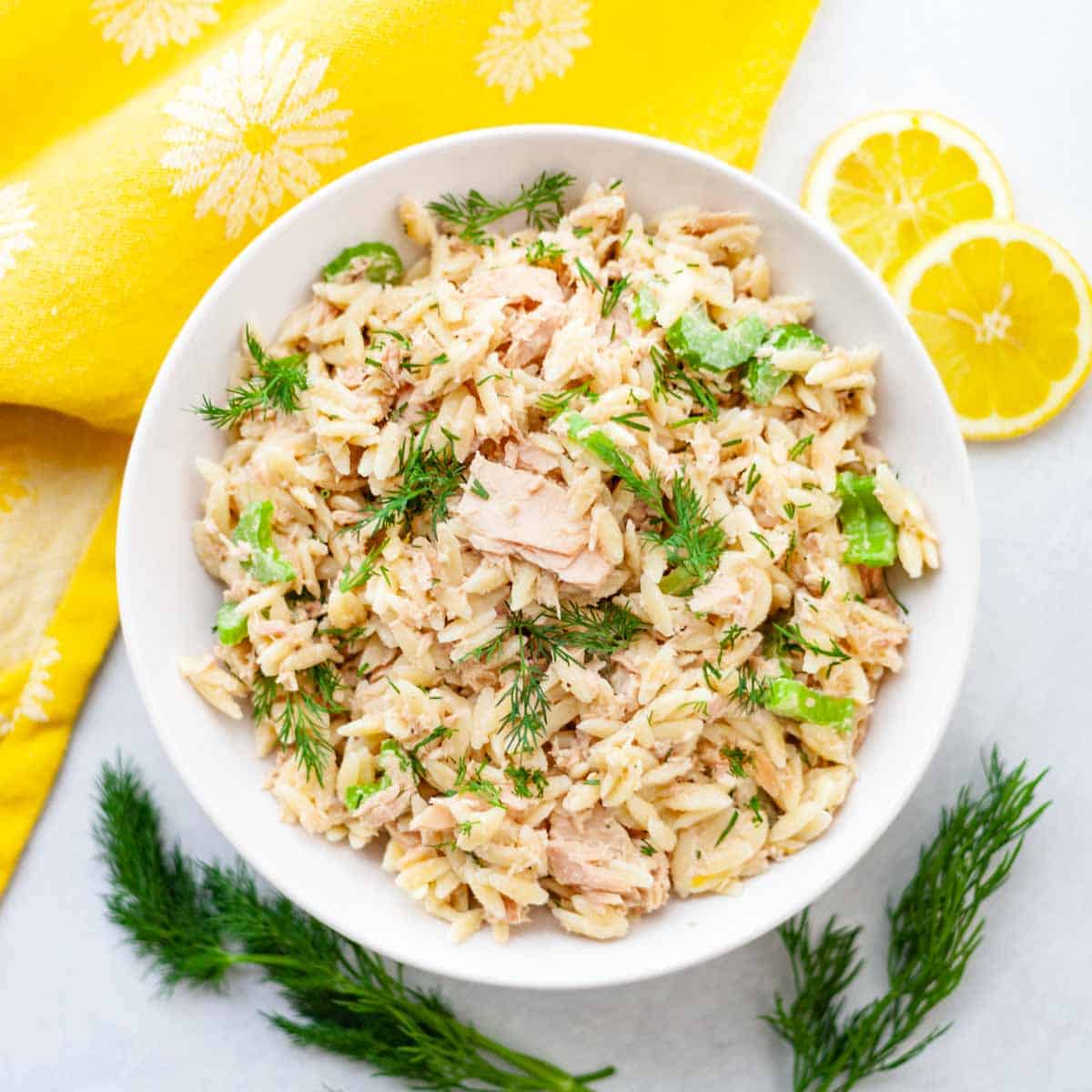 white bowl of canned tuna and orzo pasta salad with fresh dill