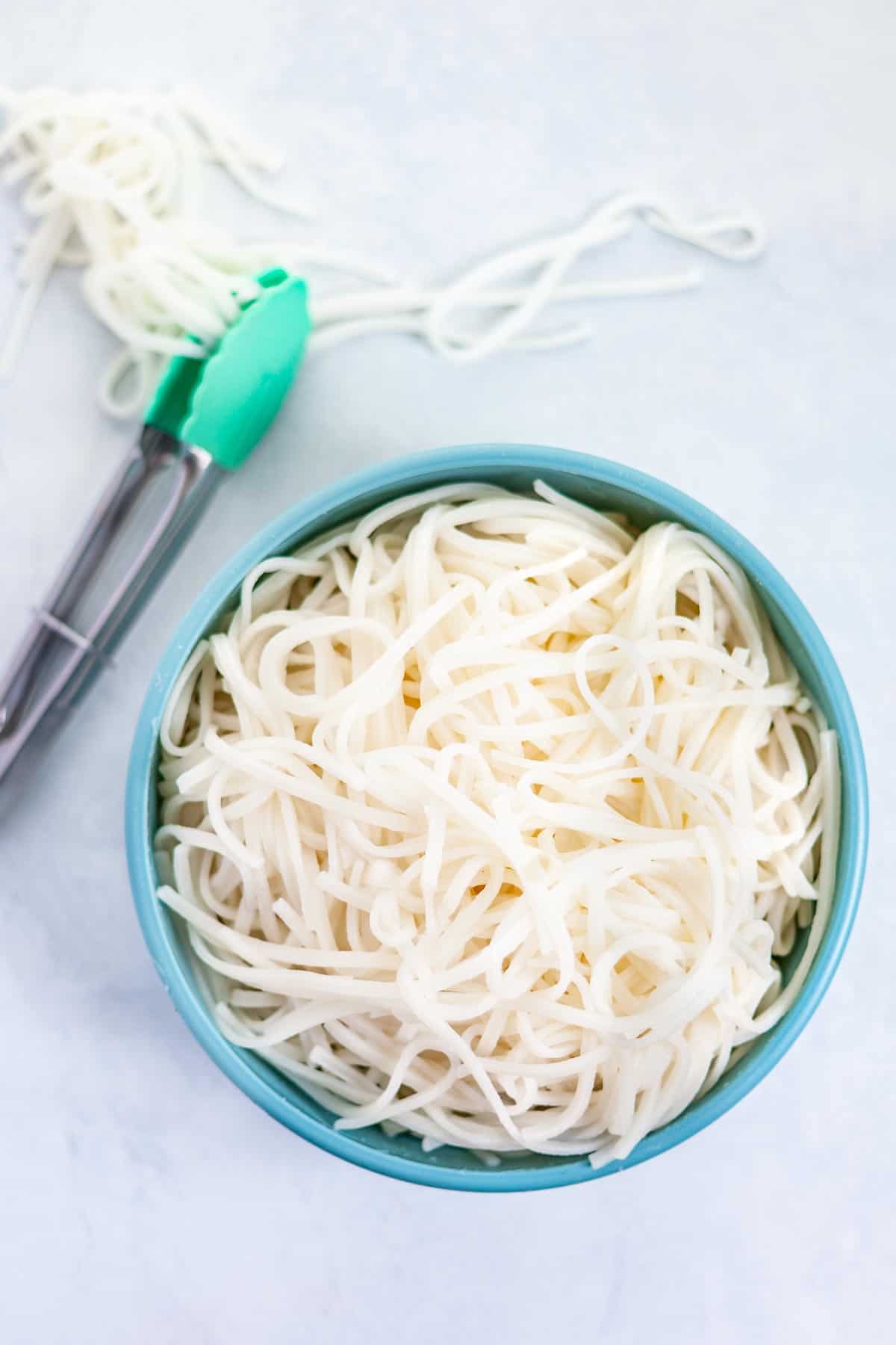 cooked rice noodles in a blue bowl