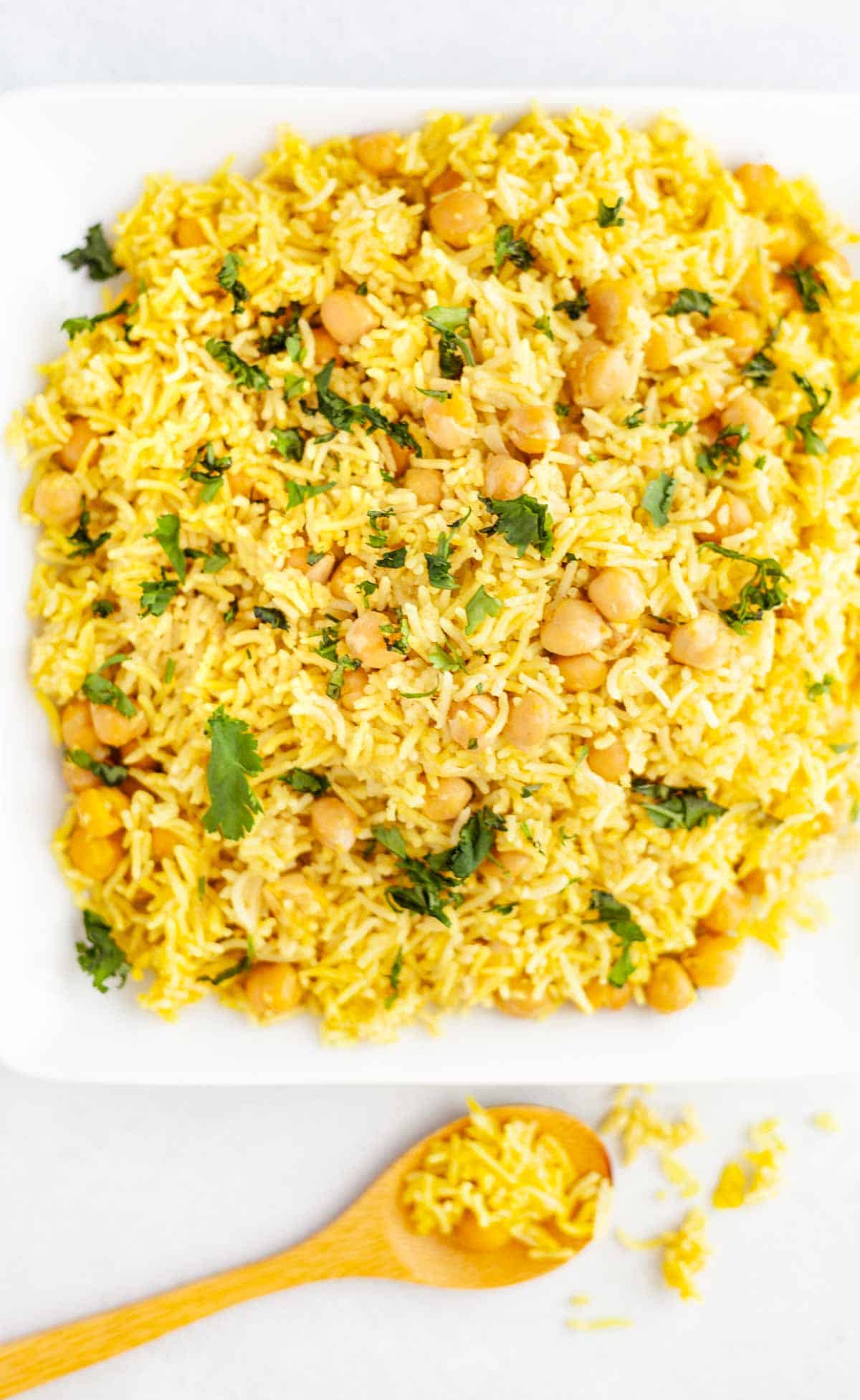 basmati rice and chickpeas on a plate, seasoned with yellow turmeric and other spices