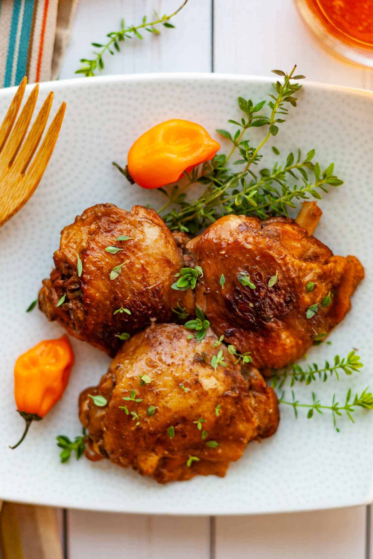 three bone-in chicken thighs cooked in a jerk chicken marinade