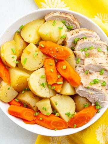 bowl of sliced chicken breast, potatoes and carrots