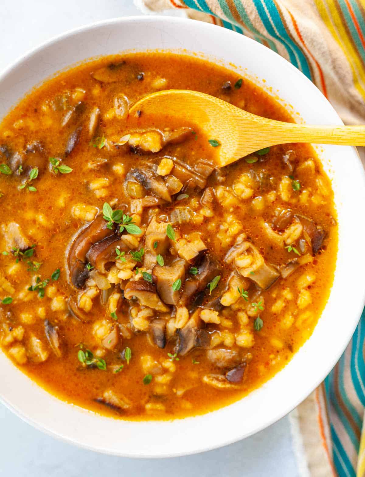 bowl of pearl barley mushroom soup with a spoon