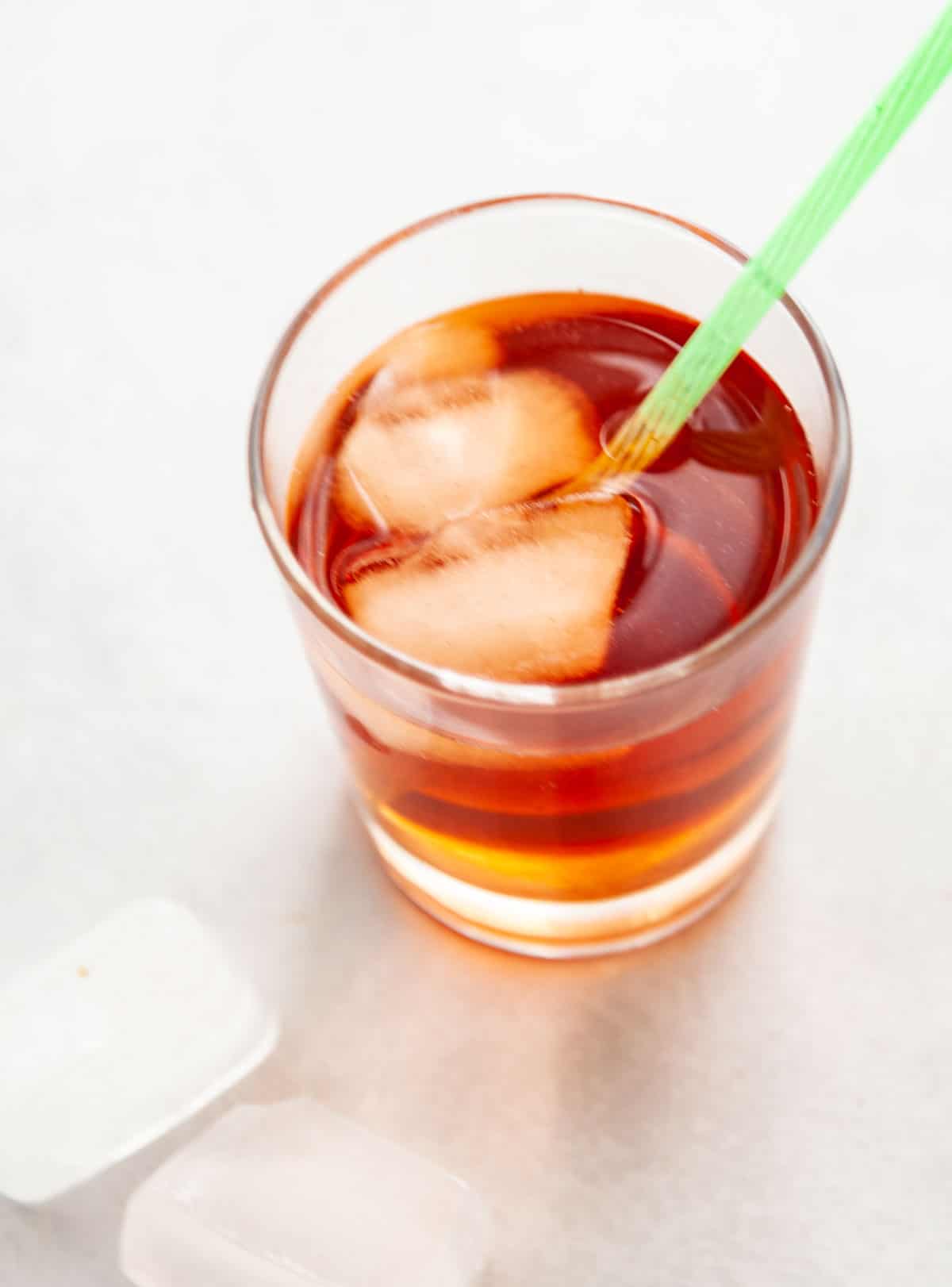 a glass of iced cinnamon tea with a straw