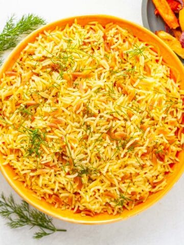 cooked white rice and orzo in a bowl garnished with dill