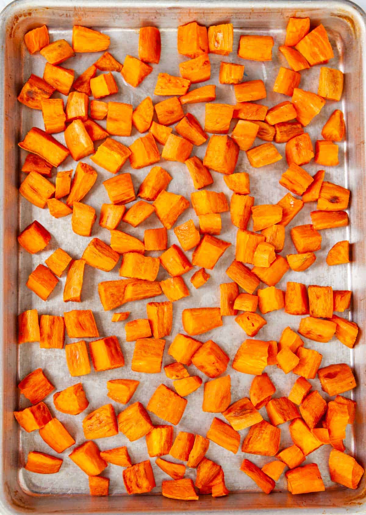 cubed, roasted sweet potatoes on a sheet pan