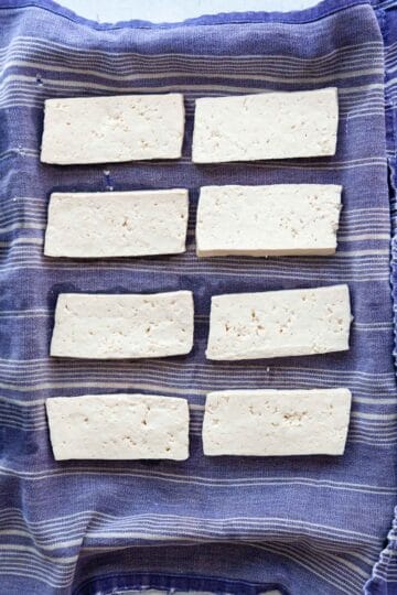 slices of uncooked tofu on a blue towell