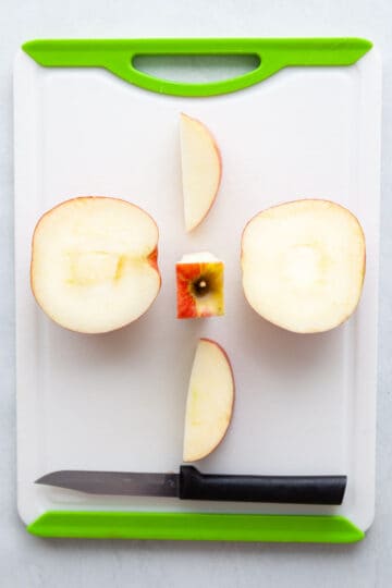 an apple sliced into four pieces around the core.