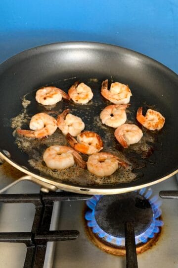 shrimp in a skillet on a gas stove