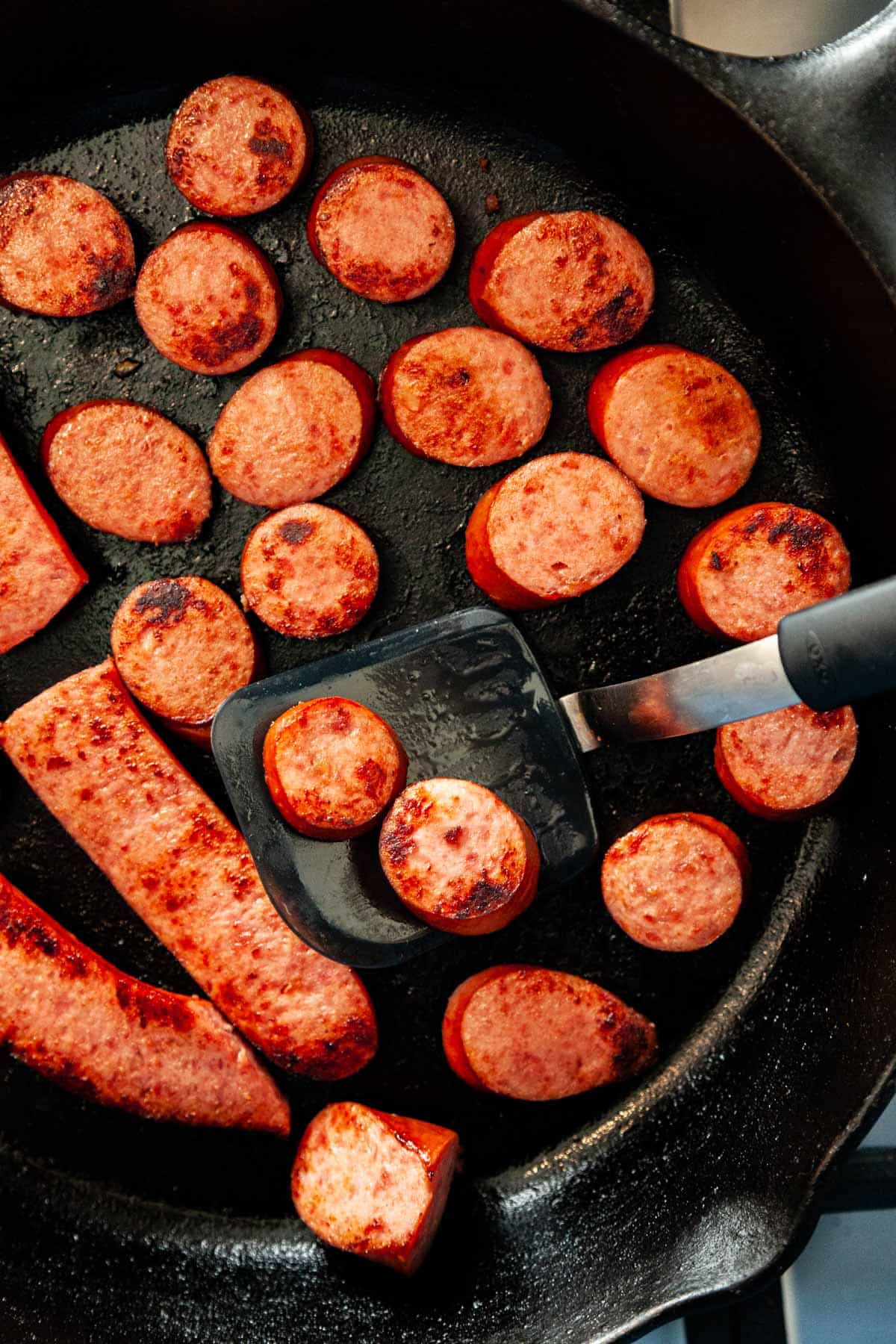 slices of kielbasa panfried in a skillet