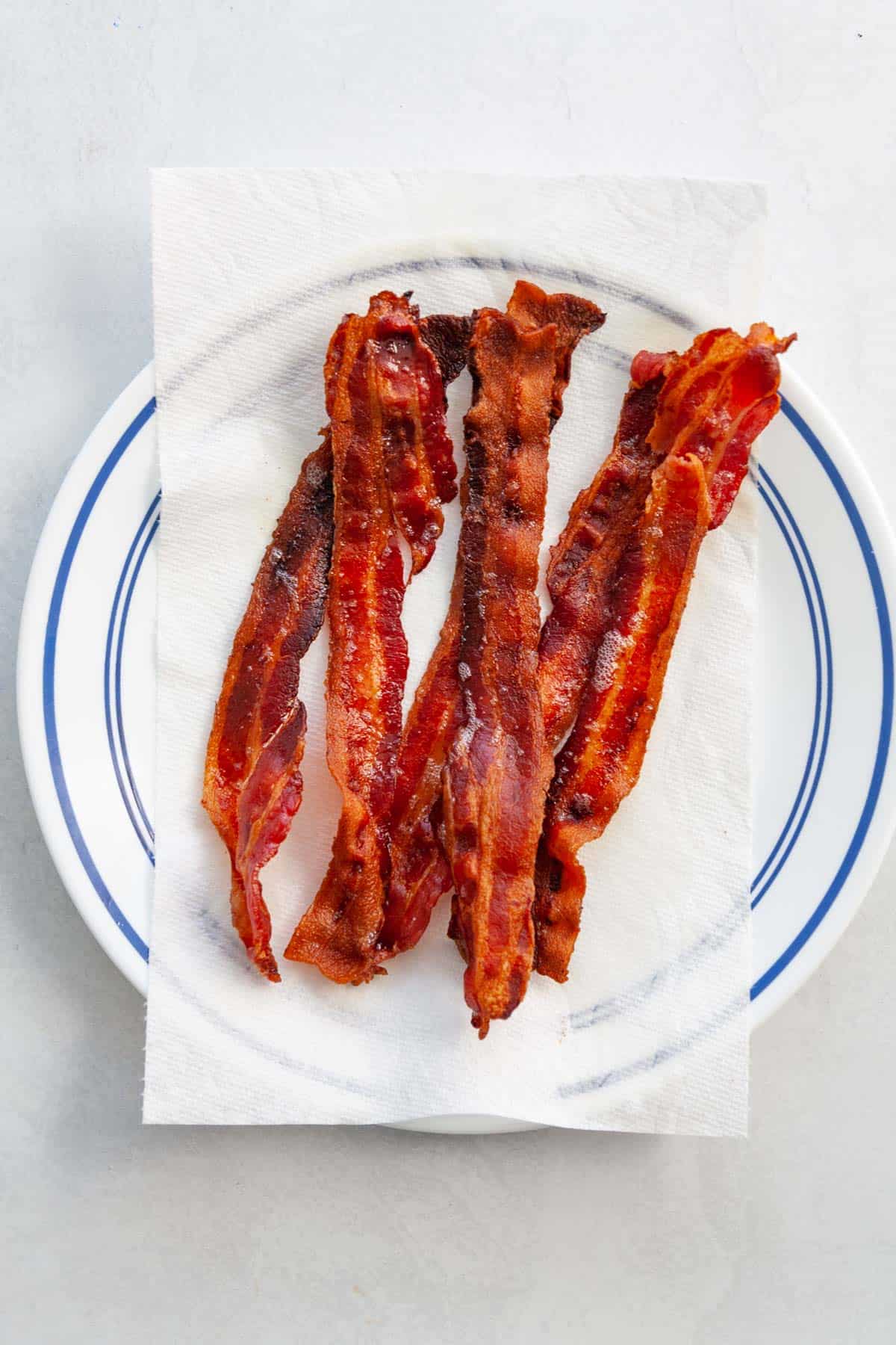 strips of cooked bacon on a plate covered with a paper towel