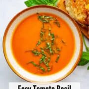 a bowl of tomato soup with grilled cheese sandwiches