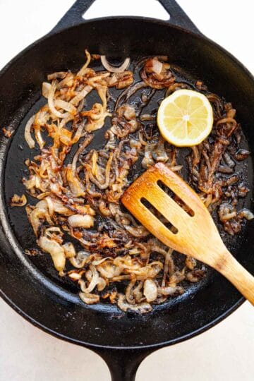 a skillet of cooked onions deglazed with a lemon
