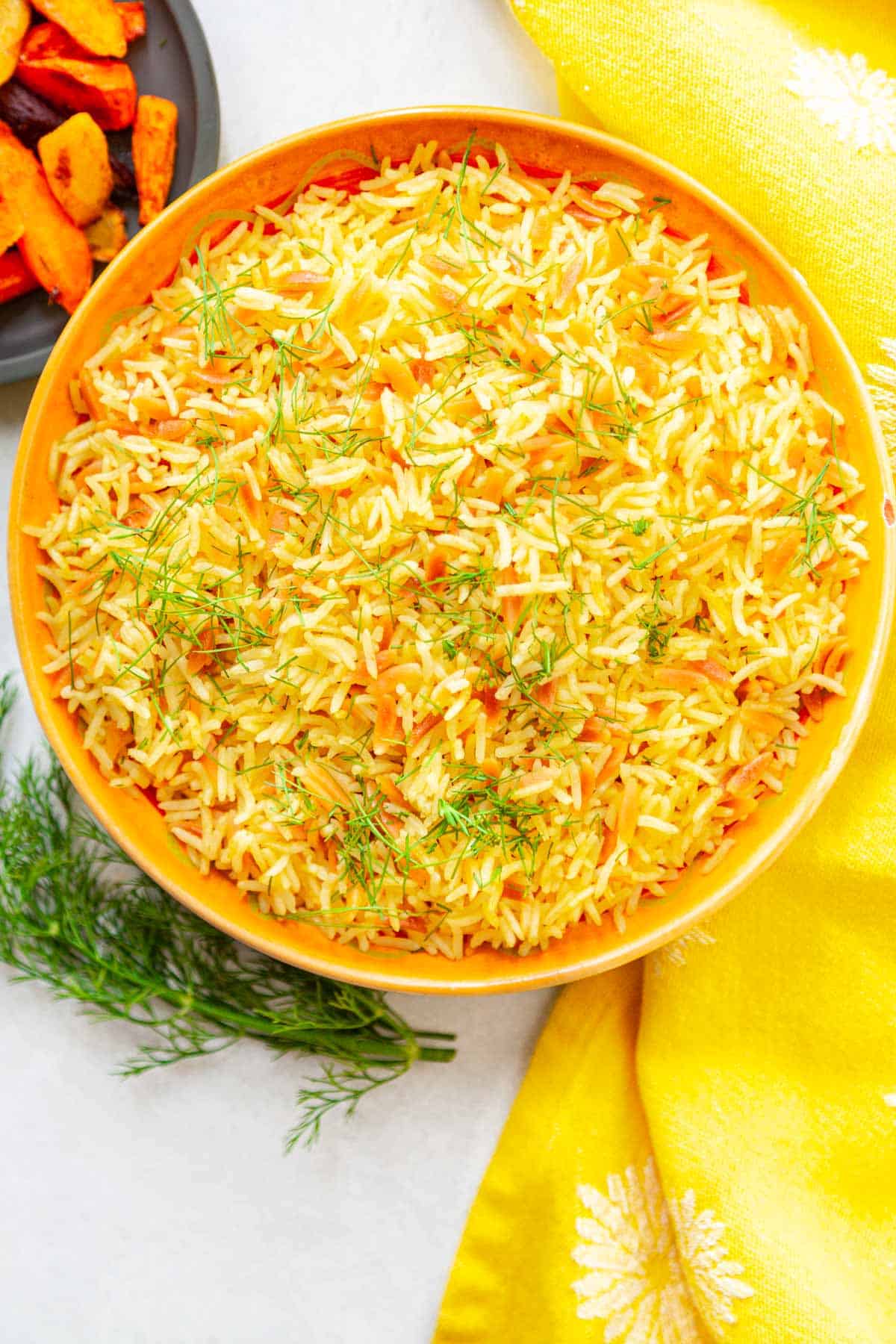 a bowl of toasted orzo cooked with rice and colored yellow with turmeric