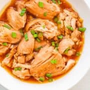 Cooked chicken thighs in sauce.