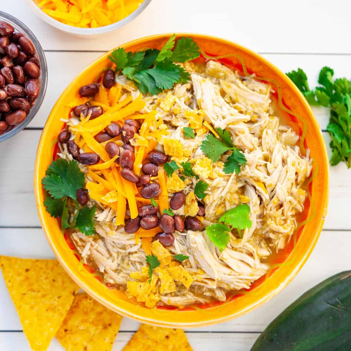 Shredded chicken in a bowl with taco toppings. 
