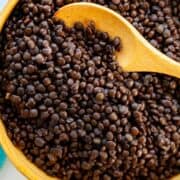 A bowl of cooked black lentils.