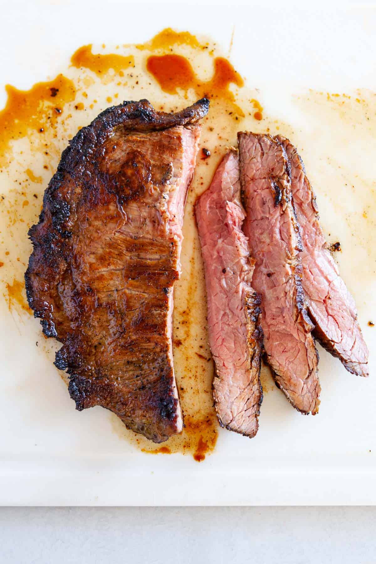 Sliced flank steak on a cutting board.